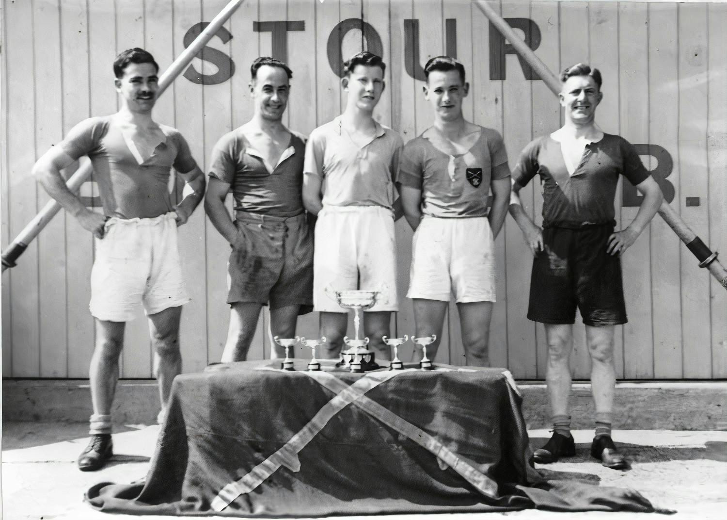 A victorious crew poses in front of the clubhouse doors, probably in the 1940s.