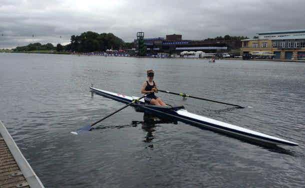 A junior single sculler at the landing stage in a large rowing lake. 